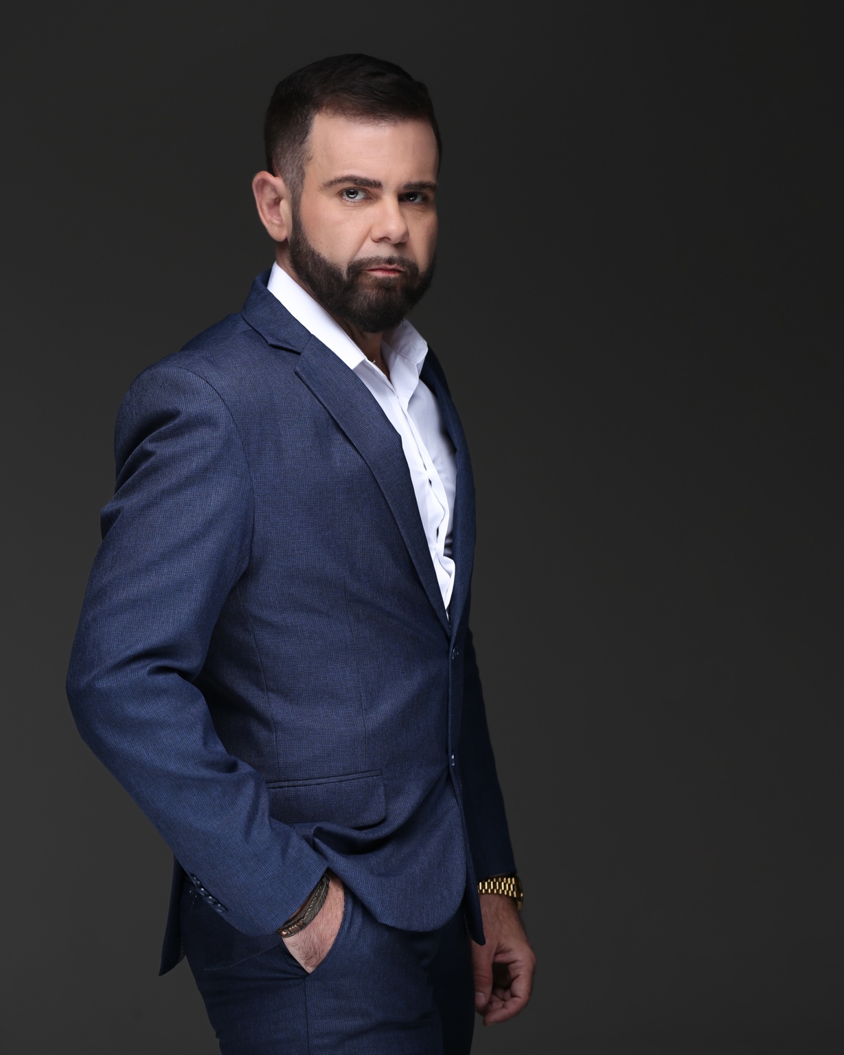 Lucas Atanazio em pé, de fato azul, num retrato de estúdio.